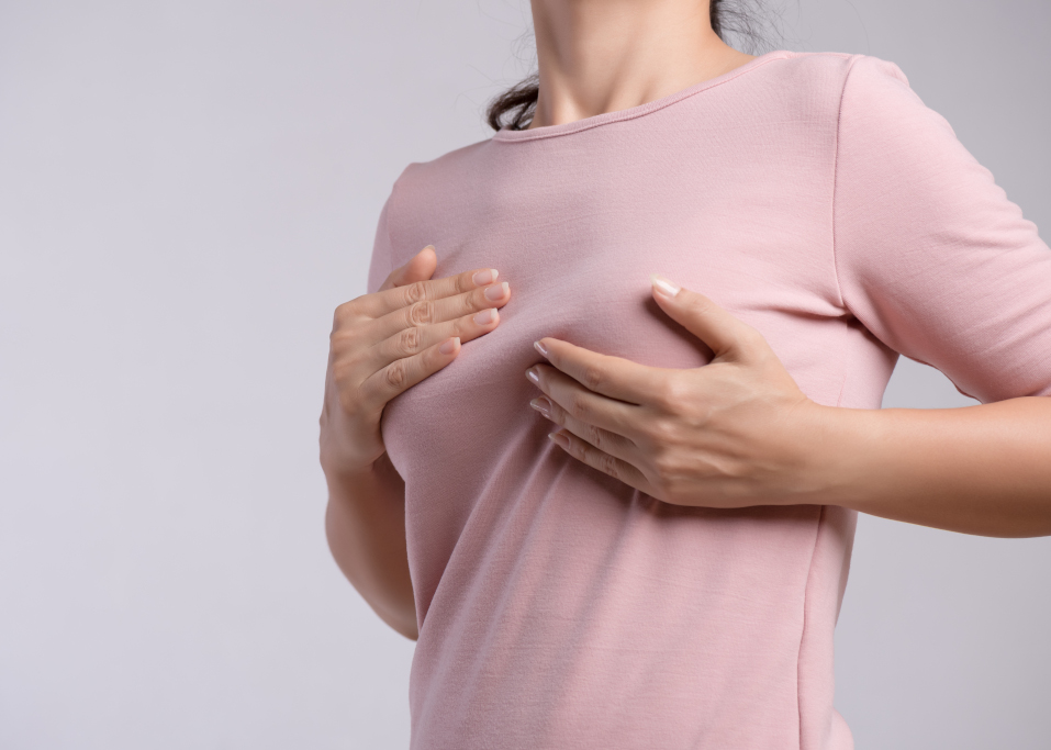 Woman hand checking lumps on her breast for signs of breast cancer Healthcare concept